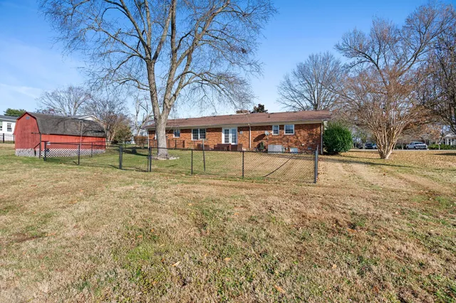 a view of a house with backyard and tree