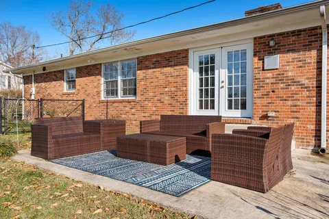 a view of a house with a barbeque and wooden stairs