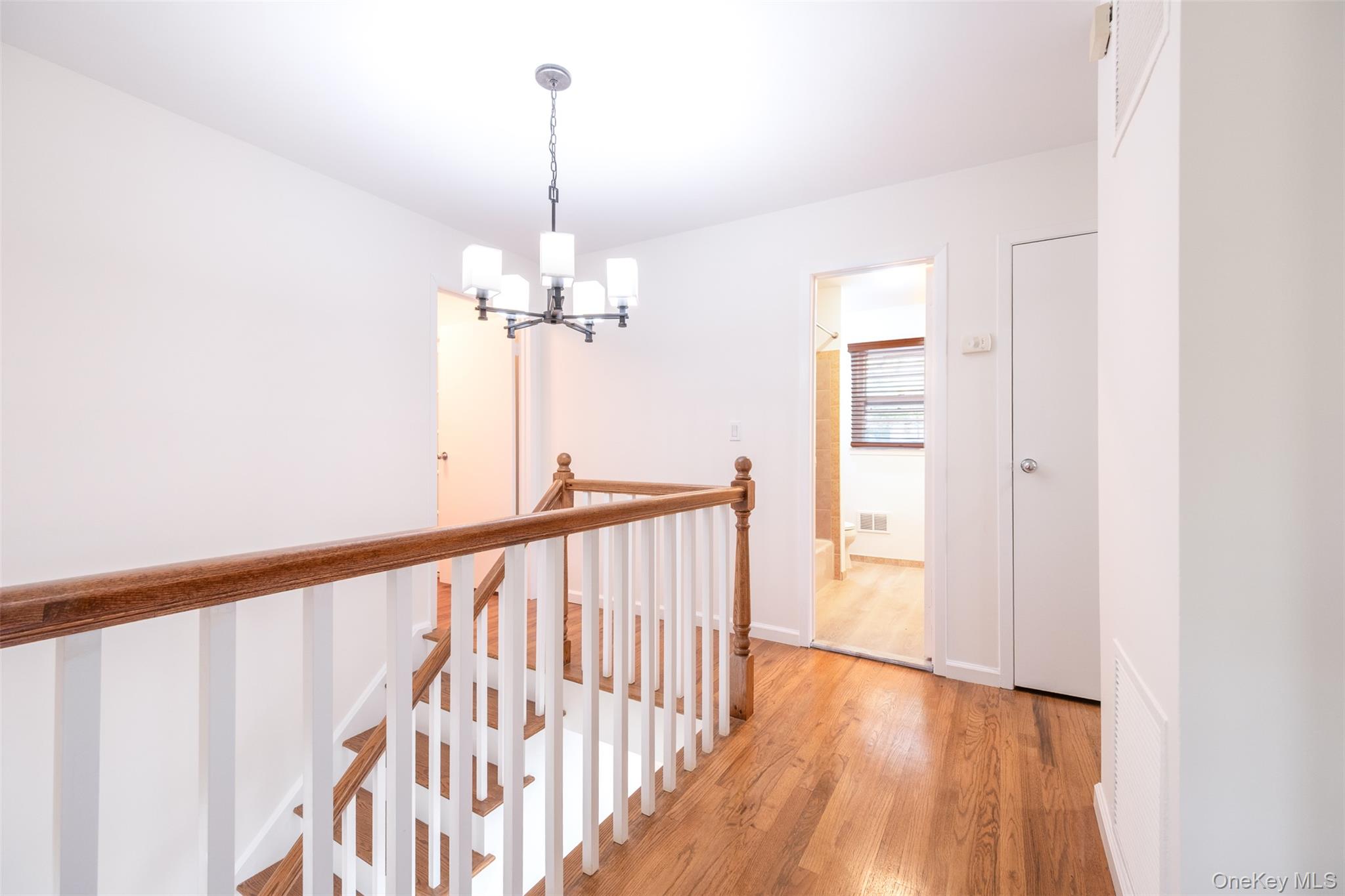 24 Sheldrake Place New Rochelle, NY 10804 - Photo 11 of 26 Hallway with an upstairs landing, a chandelier, and light wood finished floors