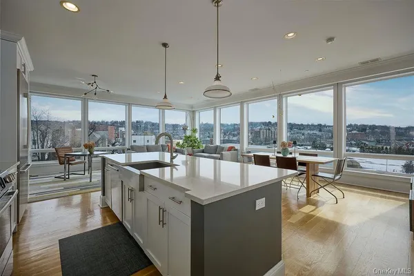 a large kitchen with kitchen island a large window in it