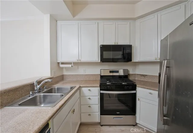 a kitchen with a sink stove and refrigerator