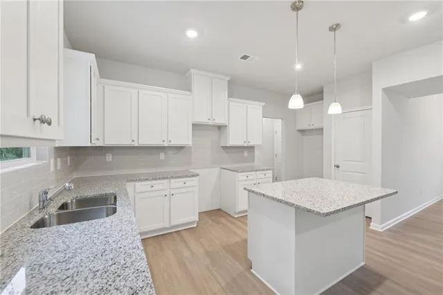 a kitchen with white cabinets appliances and sink