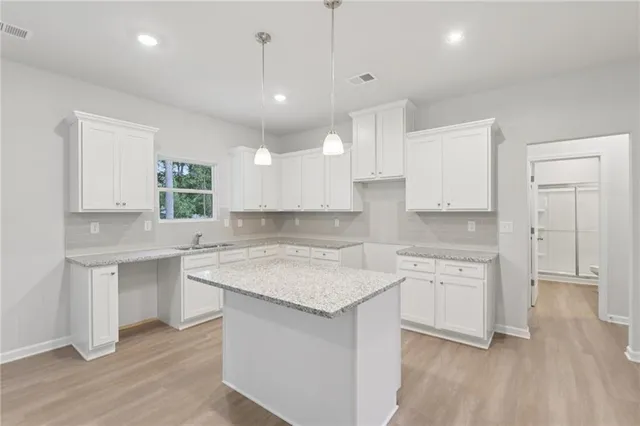 a kitchen with a sink cabinets and wooden floor