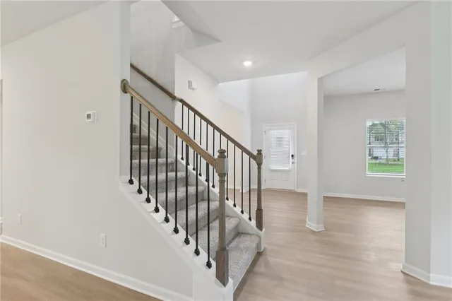 a view of staircase with railing and white walls