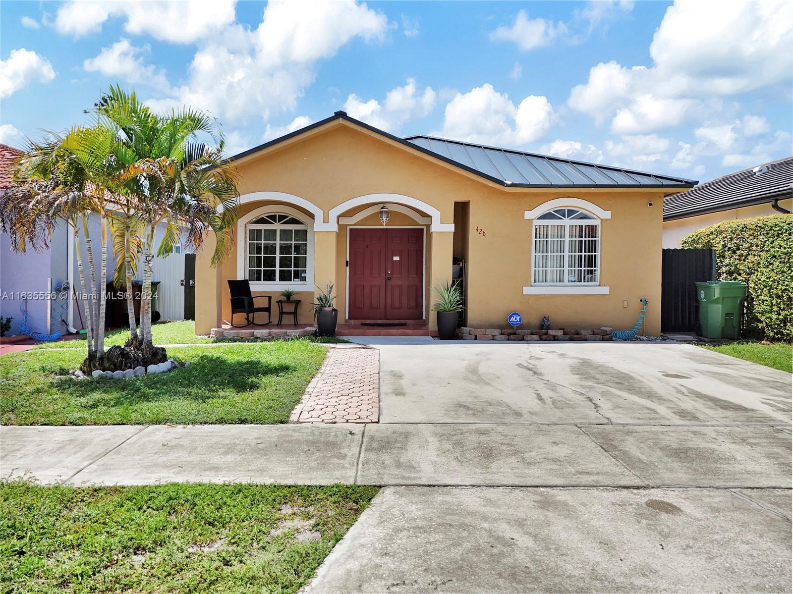 426 West 70th Street Hialeah, FL 33014 - Photo 1 of 26 a front view of a house with a garden and plants