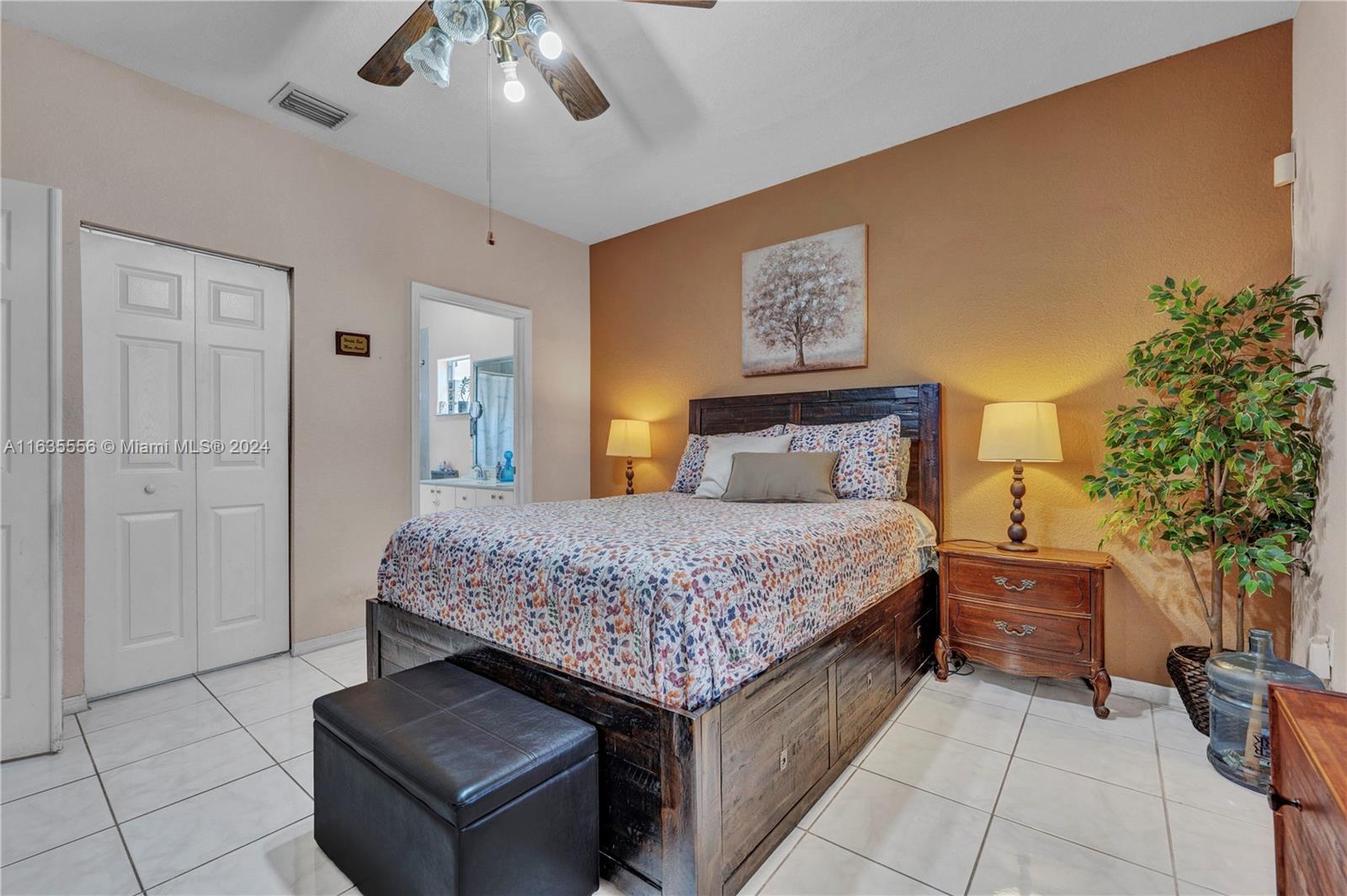 426 West 70th Street Hialeah, FL 33014 - Photo 12 of 26 a bedroom with a large bed and a chandelier
