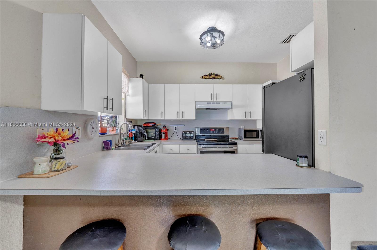 426 West 70th Street Hialeah, FL 33014 - Photo 23 of 26 a kitchen with a sink a stove and cabinets