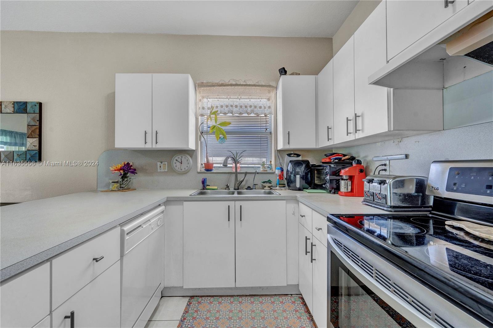 426 West 70th Street Hialeah, FL 33014 - Photo 8 of 26 a kitchen with white cabinets and appliances