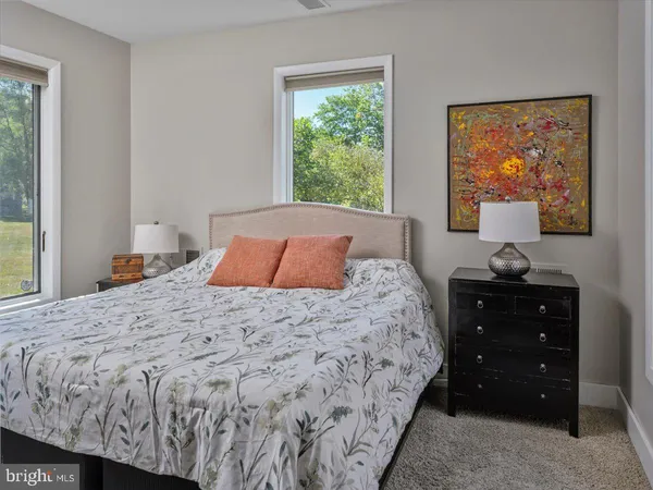 a bedroom with a bed large window and wall painting