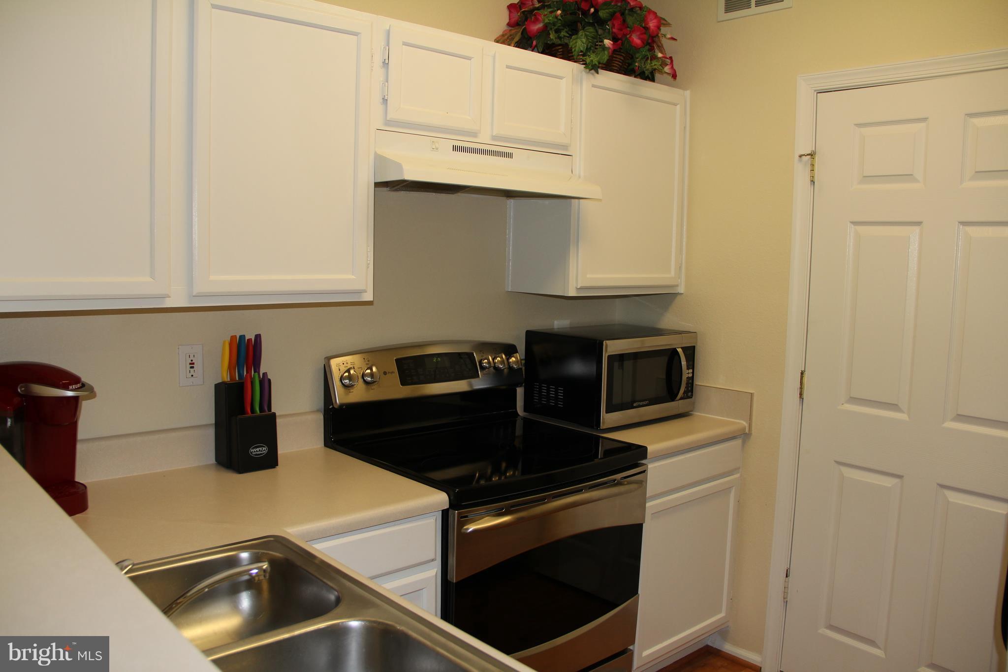 1580 Spring Gate Dr., Unit 4102 McLean, VA 22102 - Photo 8 of 26 a kitchen with white cabinets and appliances