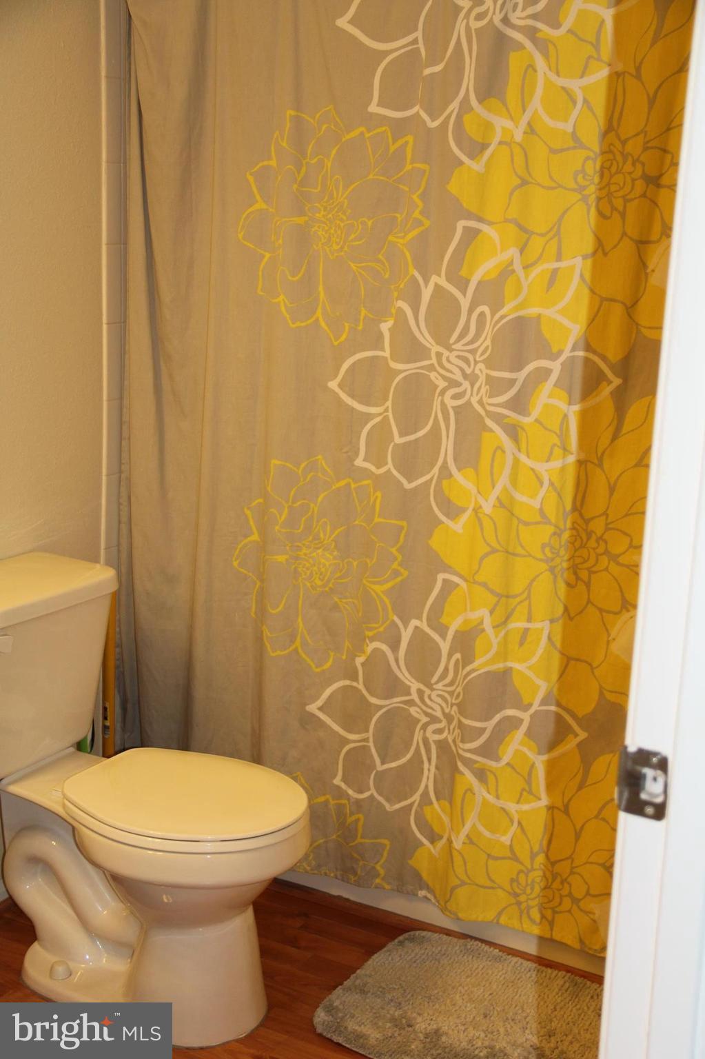 1580 Spring Gate Dr., Unit 4102 McLean, VA 22102 - Photo 10 of 26 a white toilet sitting next to a shower curtain