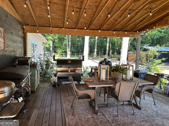 a kitchen with a dining table cabinets appliances and wooden floor