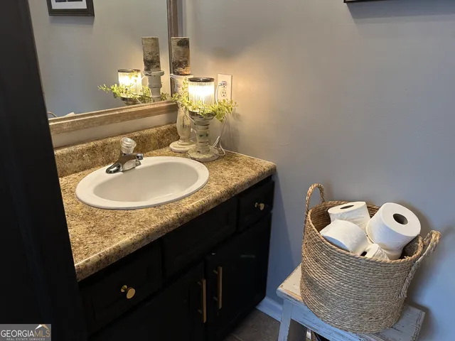 a bathroom with a granite countertop sink toilet and mirror