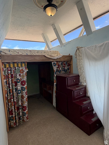 255 E Centre Spring City, UT 84662 - Photo 25 of 34 Lofted sleeping area featuring a built-in wooden staircase with integrated drawer storage, textured ceiling, and upper windows