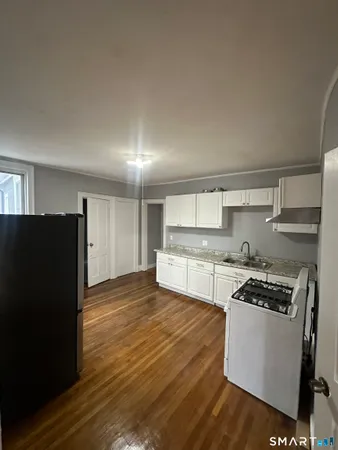 a kitchen with granite countertop a stove and a refrigerator