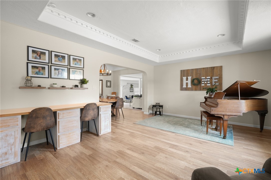 9725 Bock Road Buda, TX 78610 - Photo 4 of 37 Recessed lighting and a coffered ceiling define this generously proportioned, well-lit living space with wood flooring.