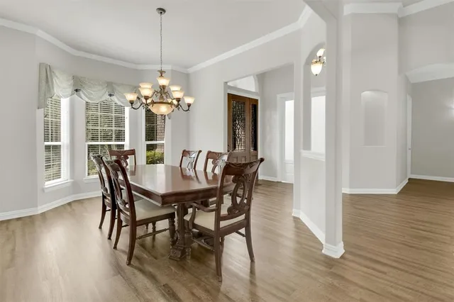 a dining room with furniture wooden floor and a chandelier