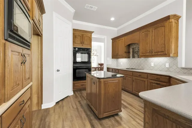 a kitchen with granite countertop a sink cabinets stainless steel appliances and a counter top space