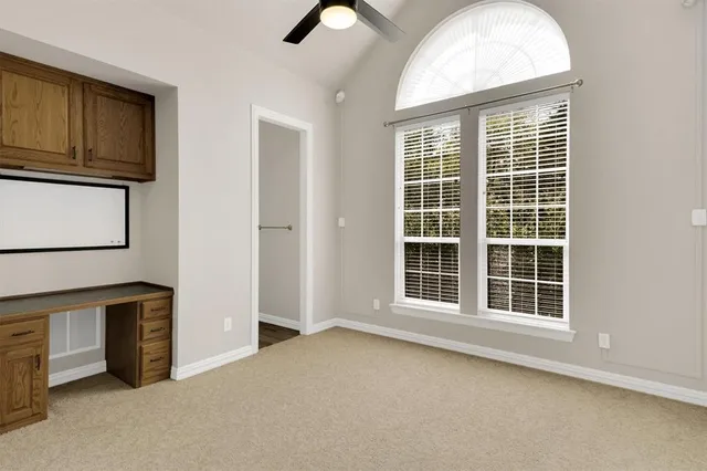 an empty room with windows and cabinet