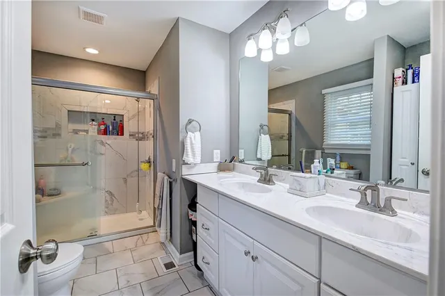 a bathroom with a double vanity sink mirror and shower