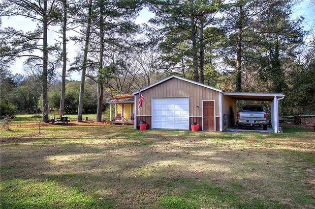 a view of a house with a yard and large tree