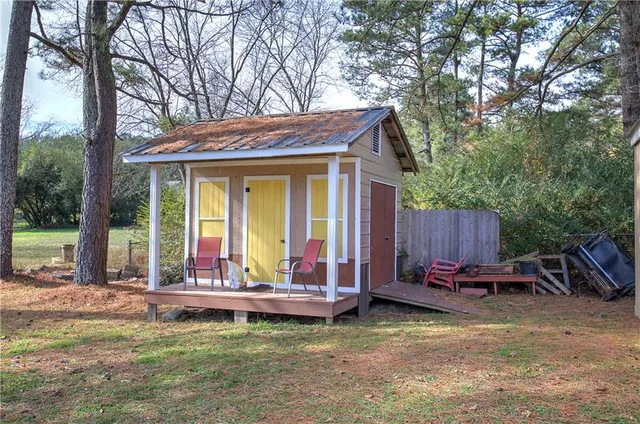 a backyard of a house with barbeque oven table and chairs