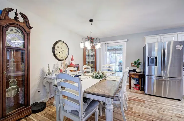 a view of a dining room with furniture a chandelier and wooden floor