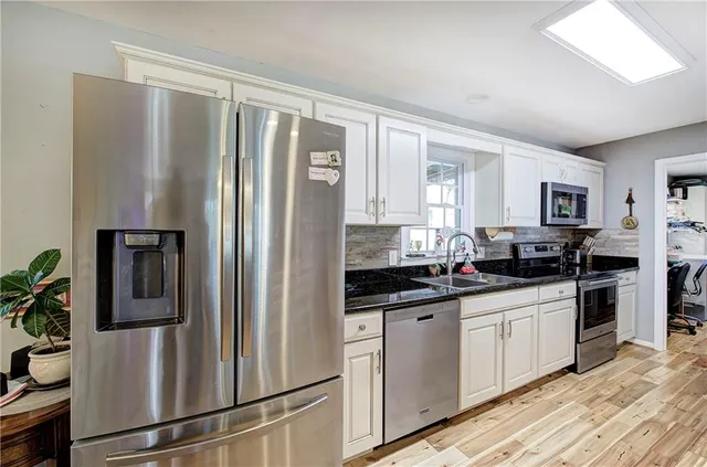 a kitchen with stainless steel appliances a refrigerator sink and cabinets