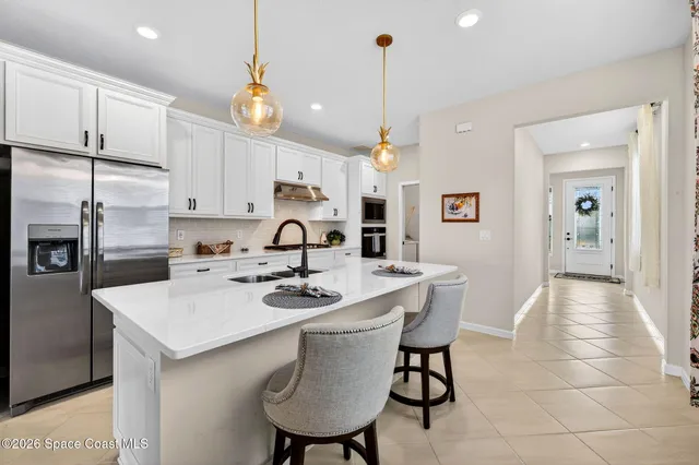 a view of a dining room with furniture a chandelier and wooden floor