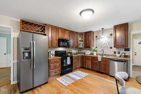 a kitchen with stainless steel appliances granite countertop a stove refrigerator and sink
