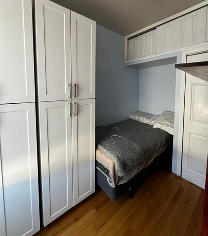 a bedroom with a bed and a refrigerator