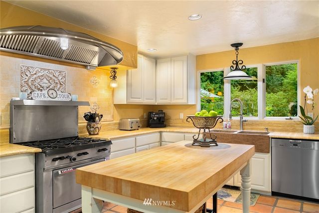 a kitchen with a table chairs sink and cabinets