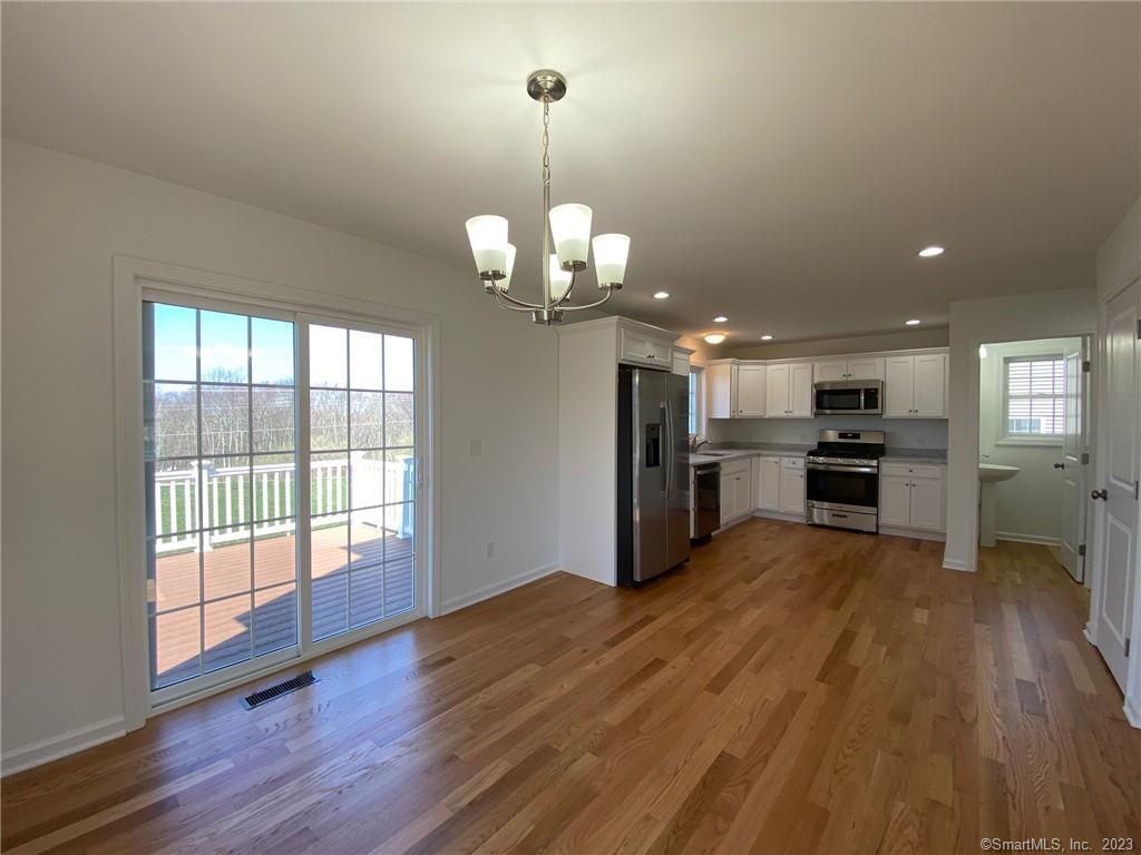 47 Rowland Farm Road, Unit 28 Oxford, CT 06478 - Photo 3 of 16 a view of a kitchen with stove and wooden floor