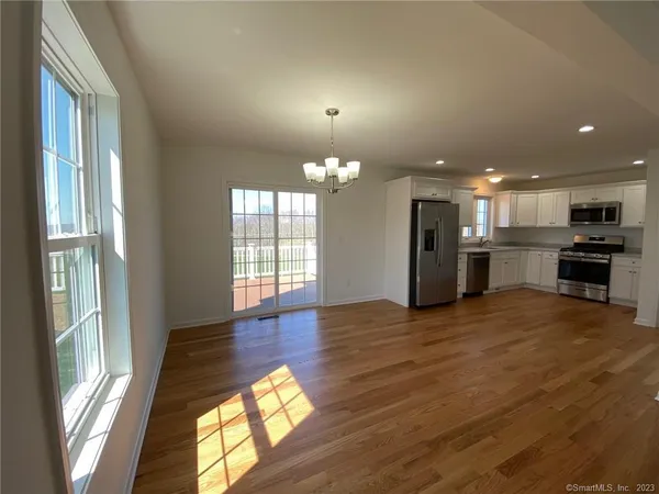 a view of empty room with wooden floor and windows