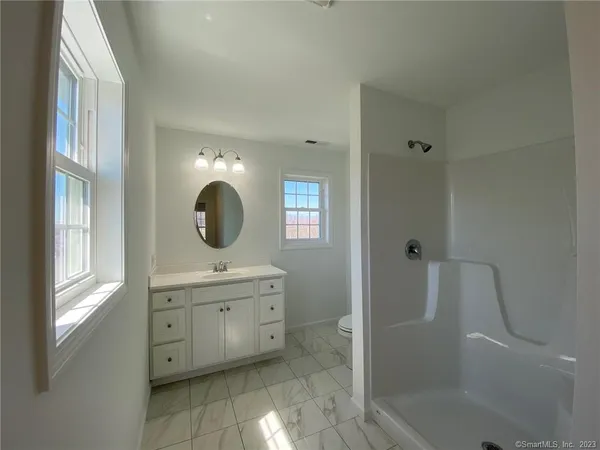 a bathroom with a sink mirror and shower