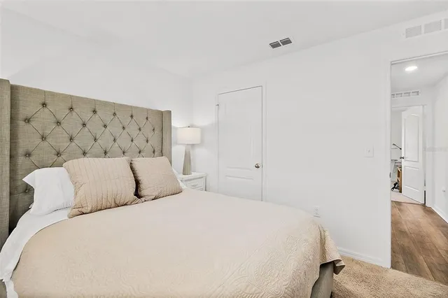 a bedroom with a bed lamp and a window