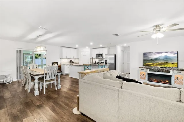 a living room with furniture a fireplace and kitchen view