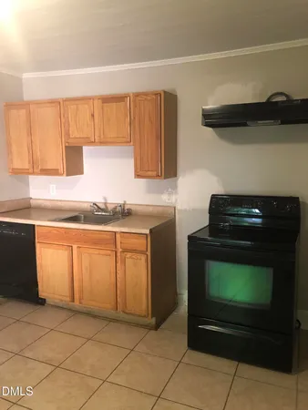 a kitchen with granite countertop a stove a sink and a microwave