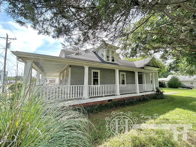 a view of a house with a wooden deck and a yard
