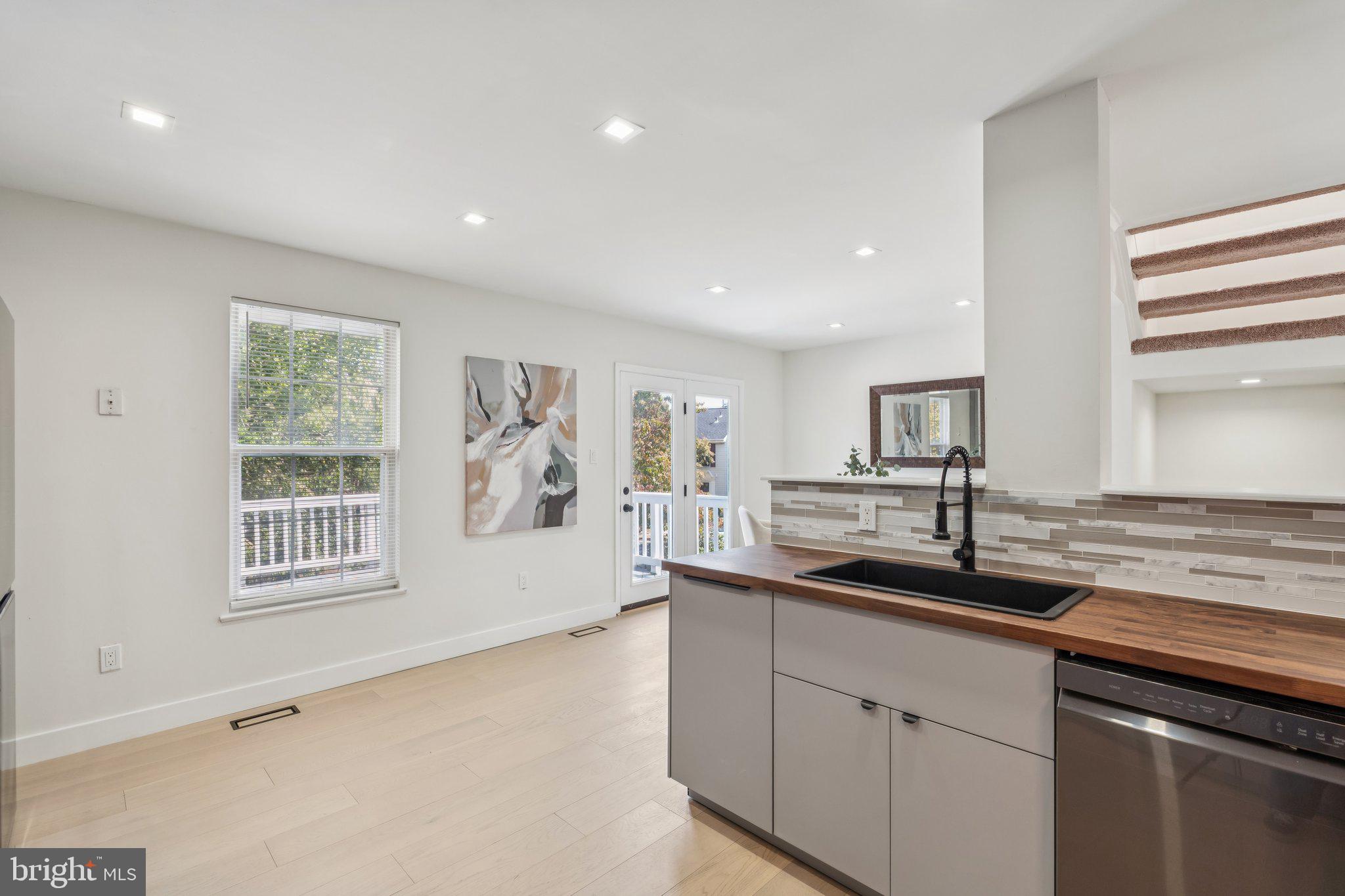 43501 Postrail Square Ashburn, VA 20147 - Photo 12 of 35 a kitchen with granite countertop kitchen island a sink wooden floor and window
