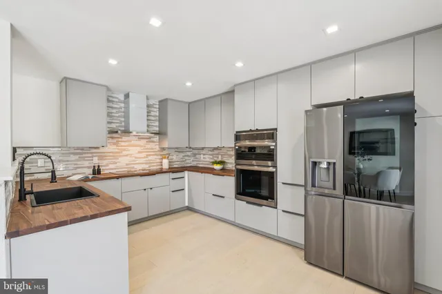 a kitchen with granite countertop a refrigerator stove top oven and sink