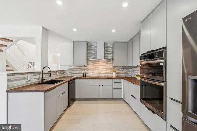 a kitchen with stainless steel appliances granite countertop a sink and stove top oven