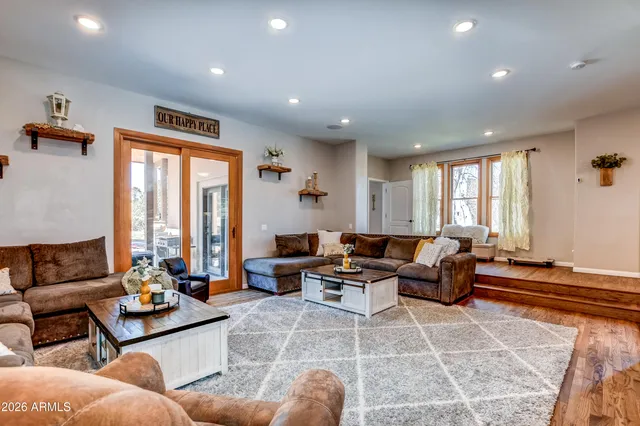 an empty room with wooden floor cabinet and windows