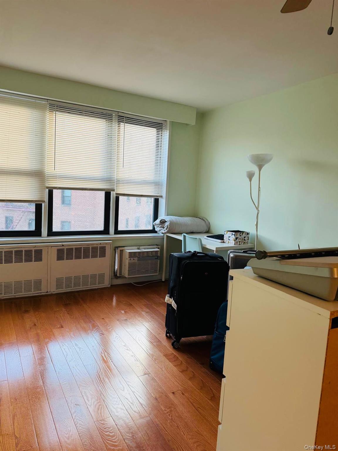 58-03 Calloway Street, Unit 6FF Queens, NY 11368 - Photo 5 of 6 a kitchen with stainless steel appliances granite countertop a refrigerator a sink dishwasher a stove and a dining table with wooden floor