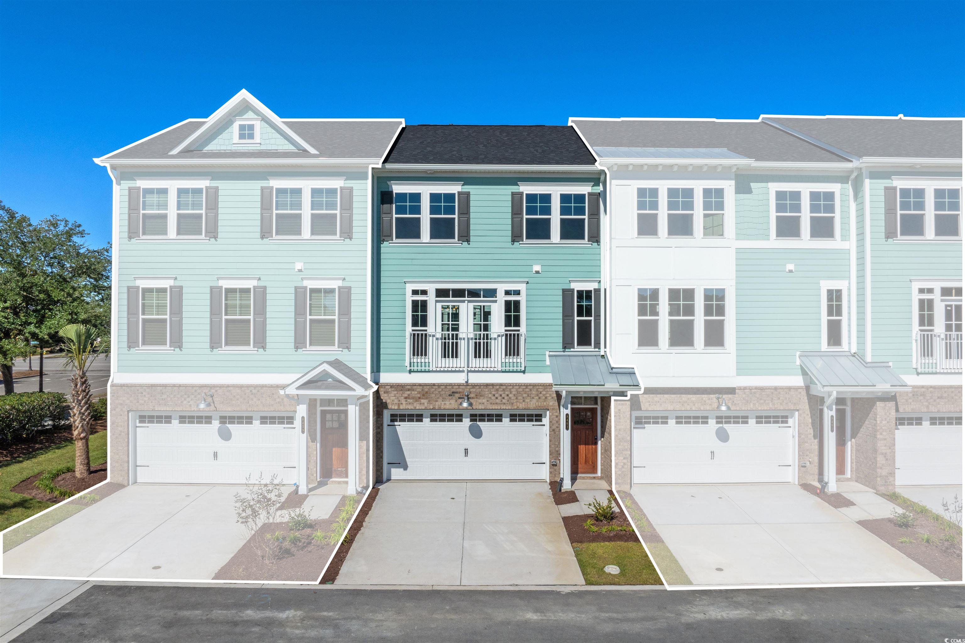 View of front of house featuring concrete driveway, an attached garage, and a balcony