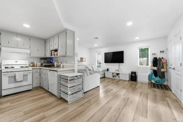 a living room with furniture wooden floor and a flat screen tv