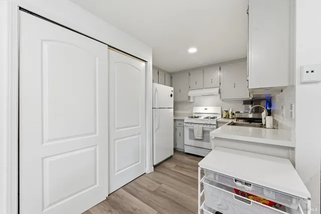 a kitchen with white cabinets and stainless steel appliances