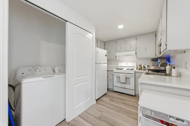 a kitchen with a refrigerator sink stove and cabinets