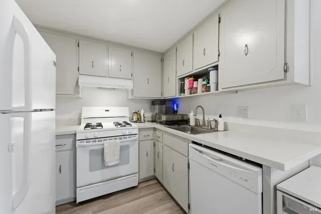 a kitchen with cabinets appliances a sink and a counter space