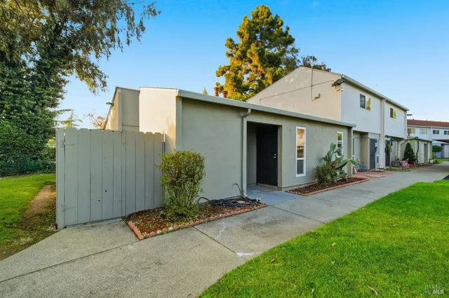 a view of a chair and table in backyard of the house